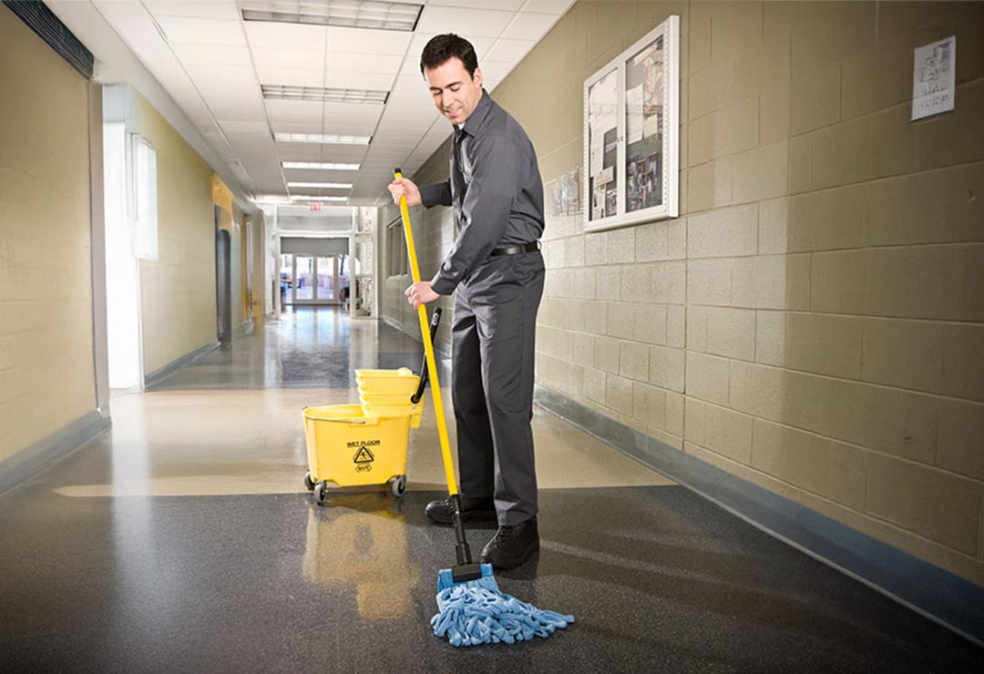 Janitor mopping the school hallway floor | Cintas