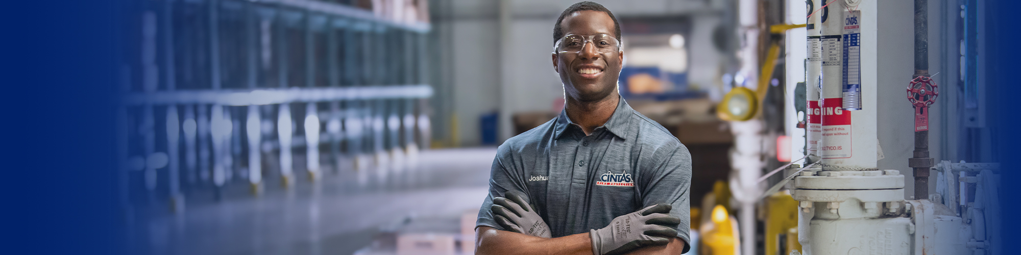 cintas fire protection service representative standing next to fire sprinkler system