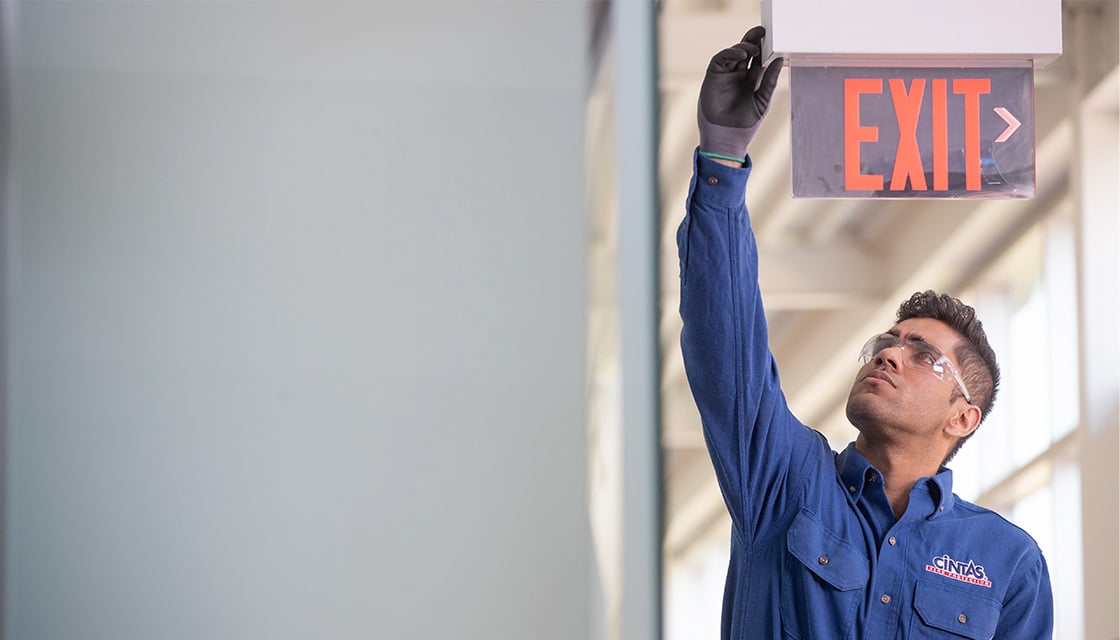 Cintas Worker Fixing Exit Sign