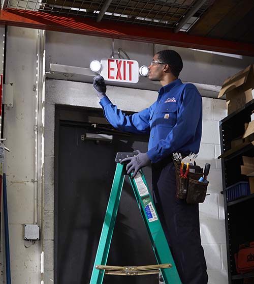 fire technician servicing exit light