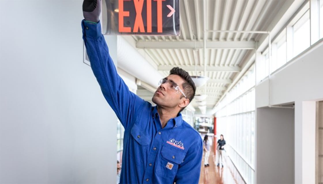 Cintas SSR examining an exit sign