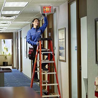 fire technician servicing exit light