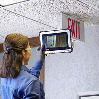fire technician servicing exit light