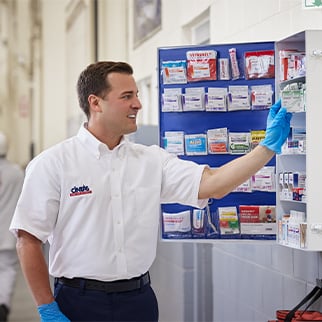 Cintas representative refilling a First Aid Cabinet