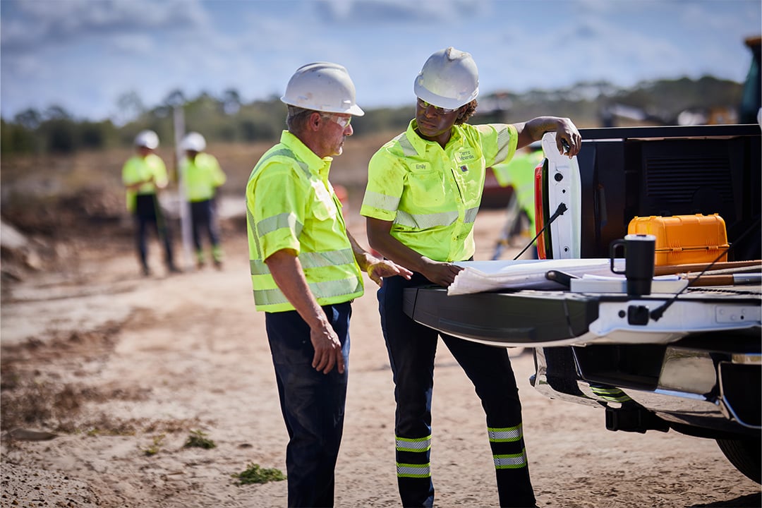 man and woman working outside near truck in hi visibility clothing